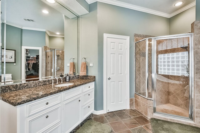 bathroom featuring ornamental molding, vanity, and a shower with shower door