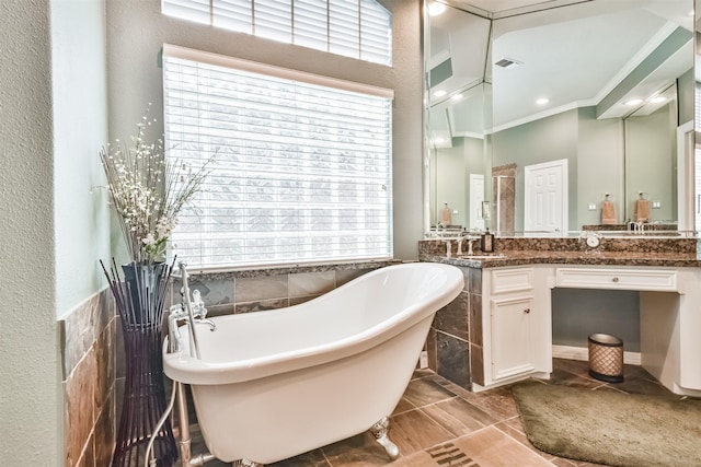 bathroom featuring vanity, plenty of natural light, a bathtub, and tile walls