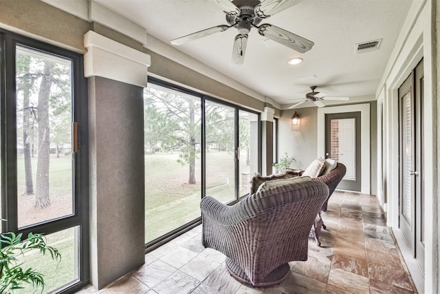 sunroom / solarium featuring ceiling fan