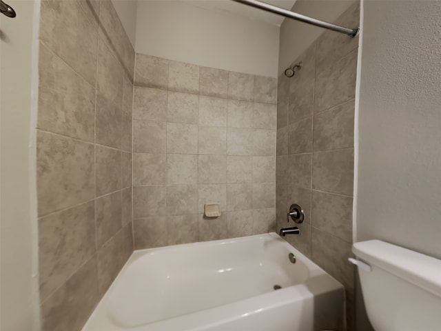 bathroom featuring tiled shower / bath combo and toilet