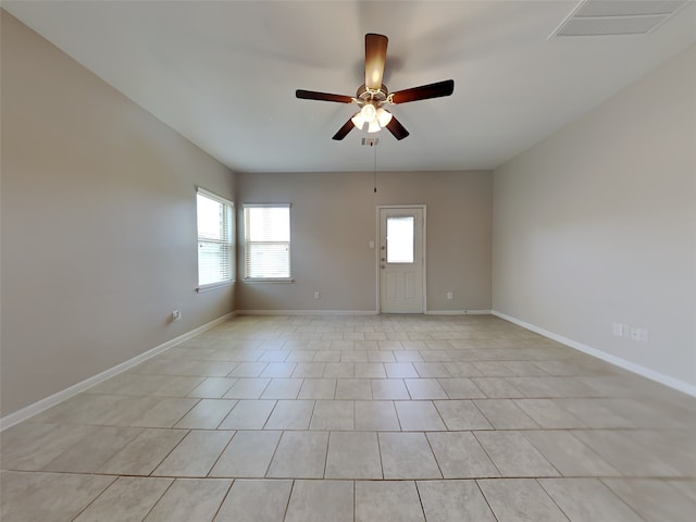 tiled empty room featuring ceiling fan