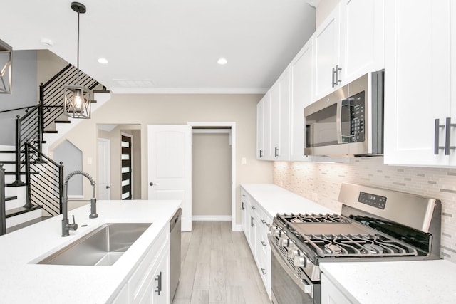 kitchen with backsplash, sink, white cabinetry, and stainless steel appliances