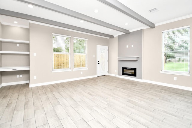 unfurnished living room featuring beamed ceiling, light hardwood / wood-style floors, and plenty of natural light