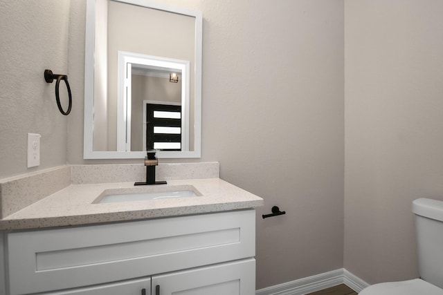 bathroom with hardwood / wood-style flooring, vanity, and toilet