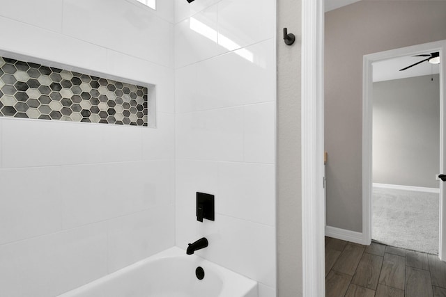 bathroom featuring ceiling fan and tiled shower / bath combo