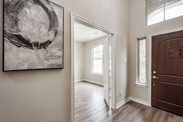 entryway with visible vents, baseboards, and wood finished floors