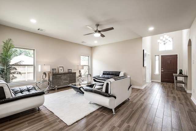 living room with dark hardwood / wood-style floors and ceiling fan with notable chandelier