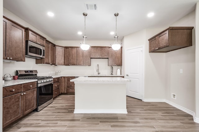 kitchen with light wood finished floors, visible vents, appliances with stainless steel finishes, and a sink