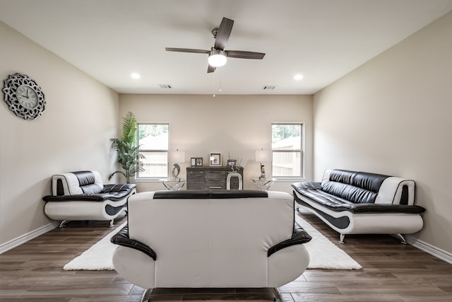 living room featuring plenty of natural light, ceiling fan, and dark hardwood / wood-style flooring