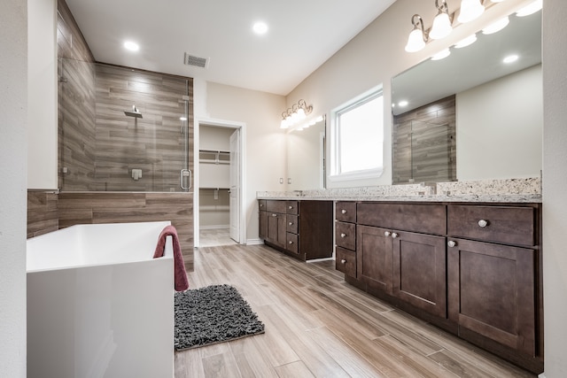 bathroom featuring double vanity and independent shower and bath