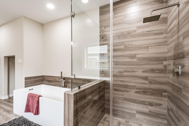 full bathroom featuring a freestanding bath and tiled shower