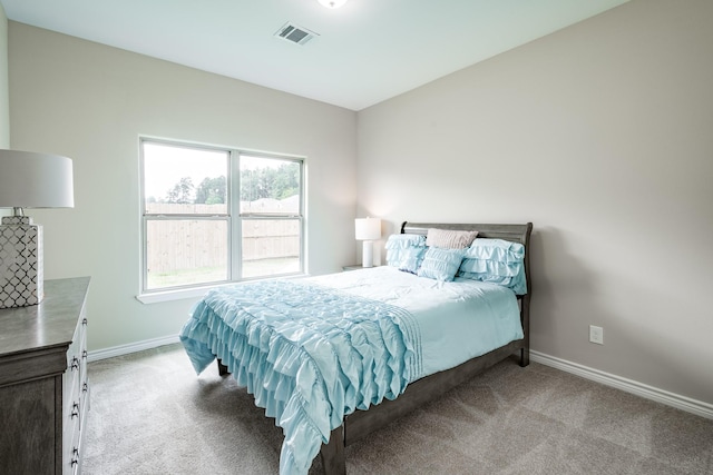 bedroom featuring visible vents, light carpet, and baseboards