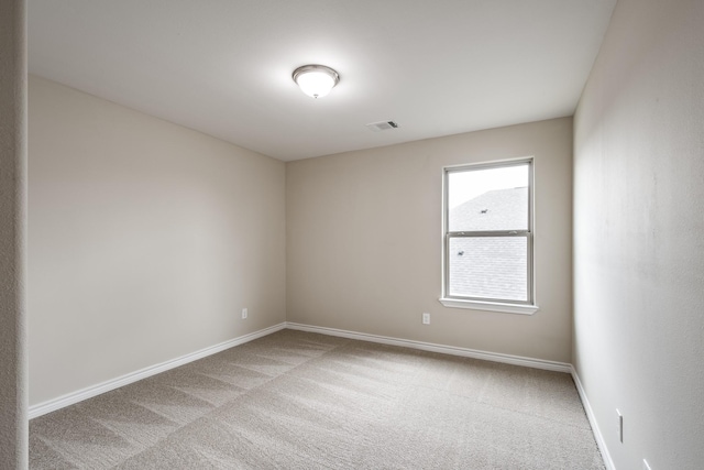 unfurnished room featuring baseboards, visible vents, and carpet flooring