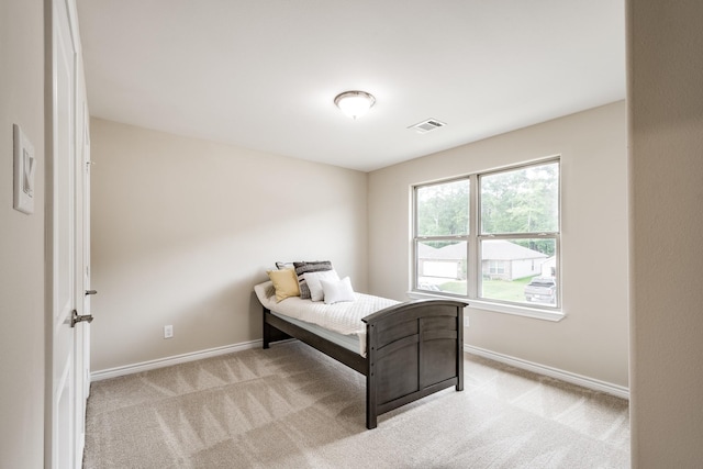 bedroom featuring light carpet, visible vents, and baseboards