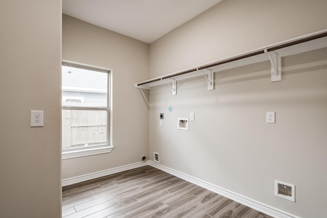 clothes washing area with hookup for a washing machine, hookup for an electric dryer, laundry area, baseboards, and light wood-type flooring