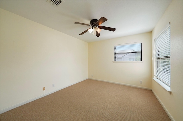 spare room with ceiling fan and light colored carpet