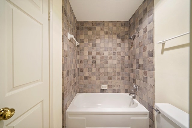 bathroom with toilet and tiled shower / bath