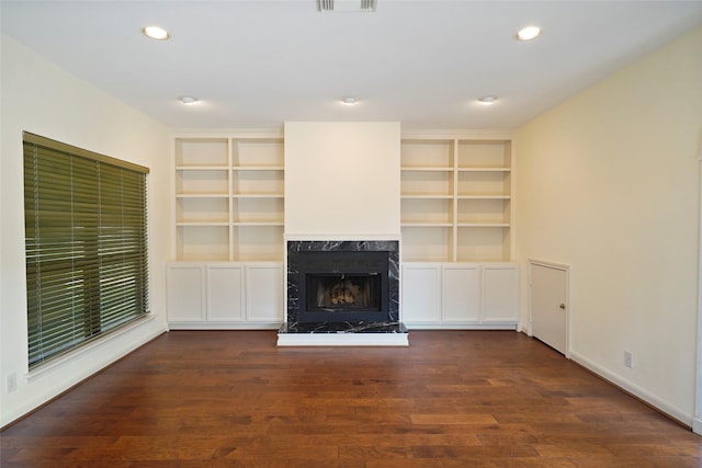 unfurnished living room featuring dark hardwood / wood-style floors and a high end fireplace