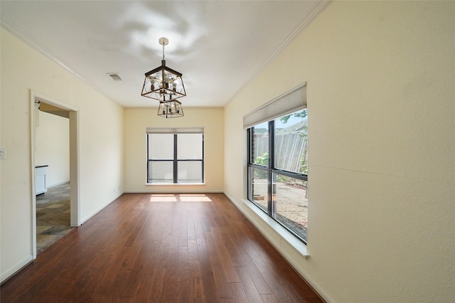 unfurnished room with crown molding, dark hardwood / wood-style flooring, and a notable chandelier