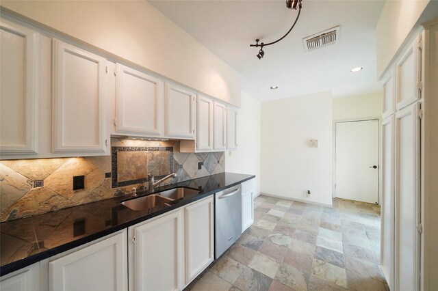 kitchen featuring white cabinets, decorative backsplash, stainless steel dishwasher, and sink