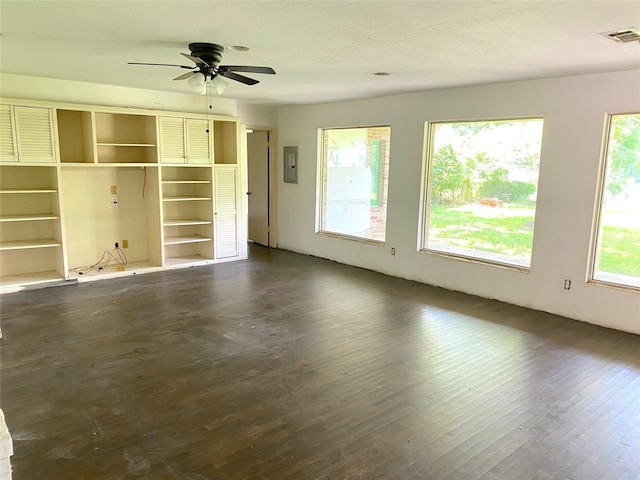 unfurnished living room with electric panel, dark hardwood / wood-style floors, and ceiling fan