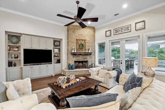 living room with french doors, crown molding, ceiling fan, a fireplace, and wood-type flooring