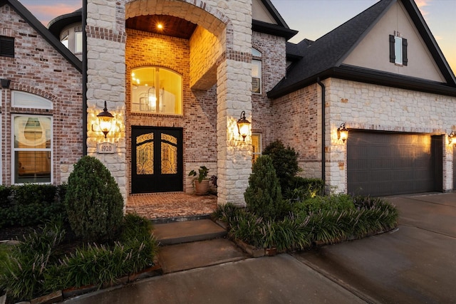 exterior entry at dusk featuring a garage