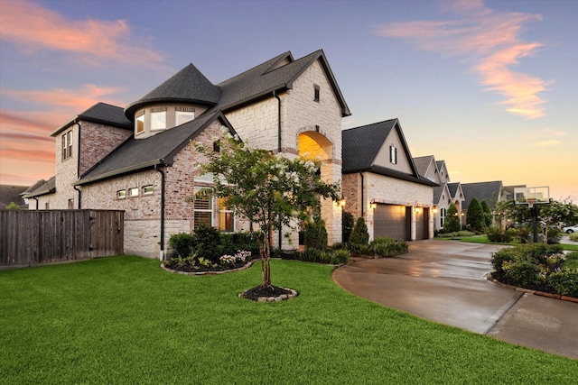 french country home with a lawn and a garage