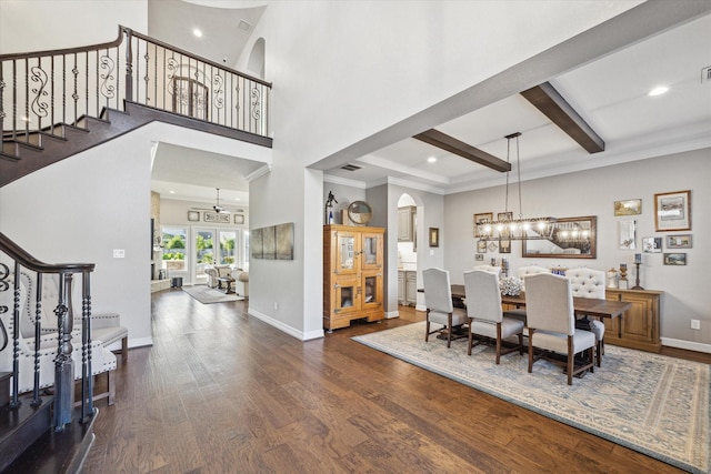 dining room featuring a towering ceiling, beam ceiling, dark hardwood / wood-style flooring, and french doors