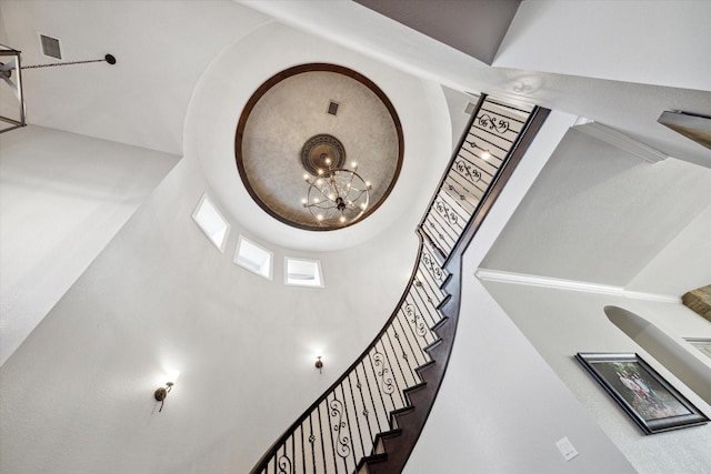 stairs with a notable chandelier and a high ceiling