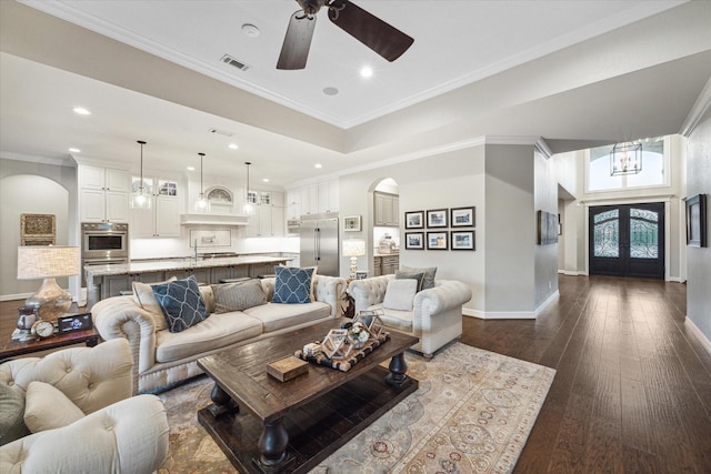 living room featuring french doors, crown molding, dark hardwood / wood-style flooring, and ceiling fan with notable chandelier