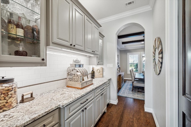 bar with backsplash, dark hardwood / wood-style floors, gray cabinets, ornamental molding, and beam ceiling