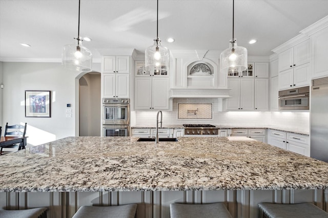 kitchen with appliances with stainless steel finishes, hanging light fixtures, and sink