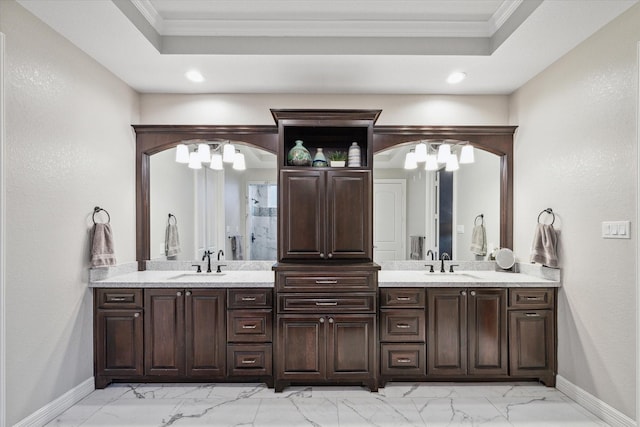 bathroom featuring a chandelier, vanity, a tray ceiling, and ornamental molding