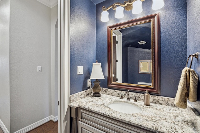 bathroom featuring hardwood / wood-style floors, vanity, and ornamental molding