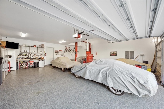 garage featuring a workshop area, electric panel, and a garage door opener