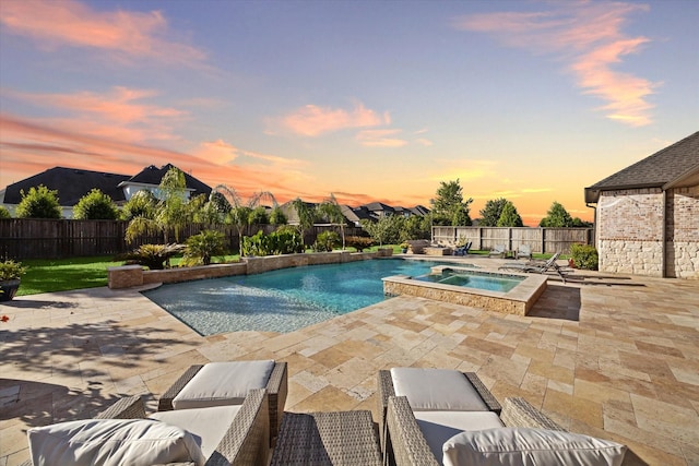 pool at dusk featuring an in ground hot tub, pool water feature, and a patio