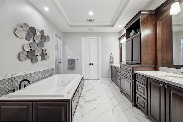 bathroom with vanity, crown molding, a tub, and a tray ceiling