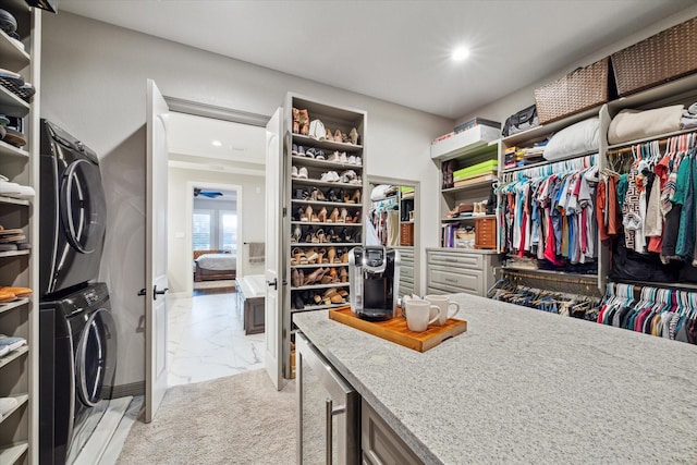 spacious closet with beverage cooler and stacked washer and clothes dryer