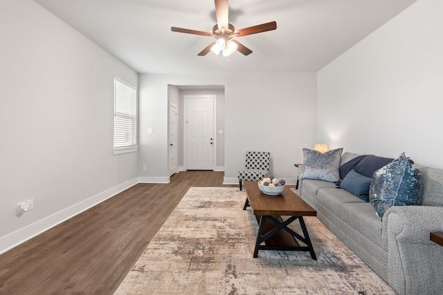 living room featuring ceiling fan and dark wood-type flooring