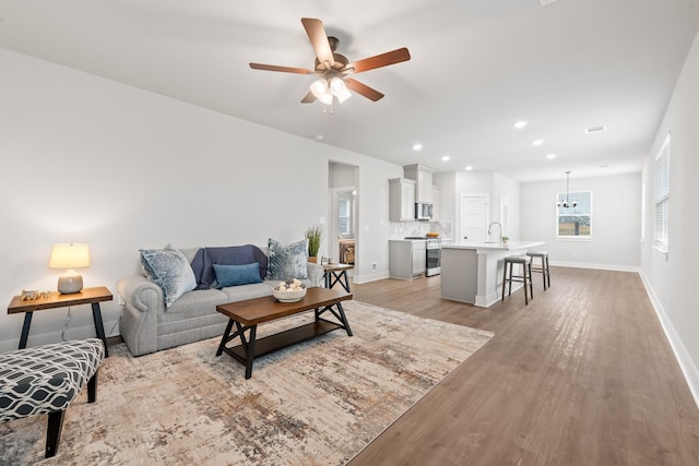 living room featuring ceiling fan and light wood-type flooring