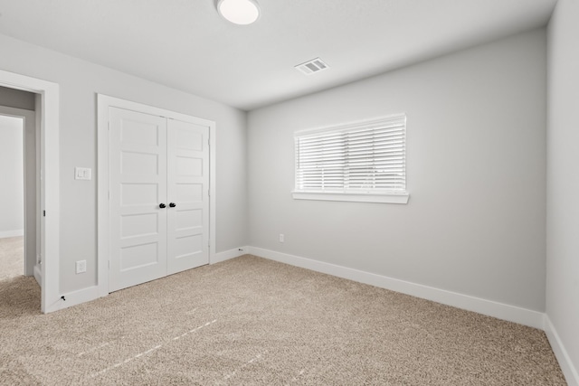 unfurnished bedroom with carpet and a closet