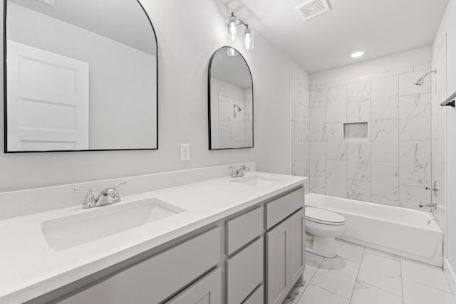 full bathroom featuring toilet, vanity, and tiled shower / bath