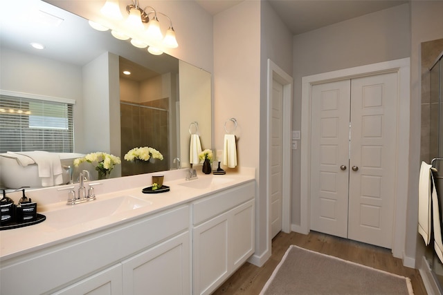 bathroom featuring vanity, wood-type flooring, and walk in shower