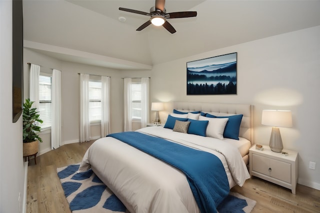 bedroom with ceiling fan, light hardwood / wood-style flooring, and lofted ceiling