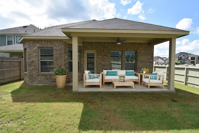 rear view of property with a yard, an outdoor living space, a patio, and ceiling fan