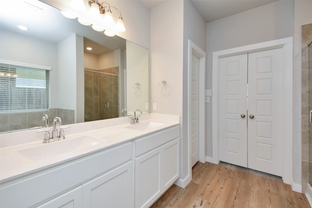 bathroom featuring hardwood / wood-style flooring, vanity, and walk in shower