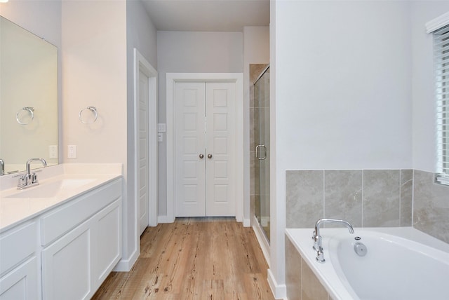 bathroom featuring vanity, shower with separate bathtub, and hardwood / wood-style flooring