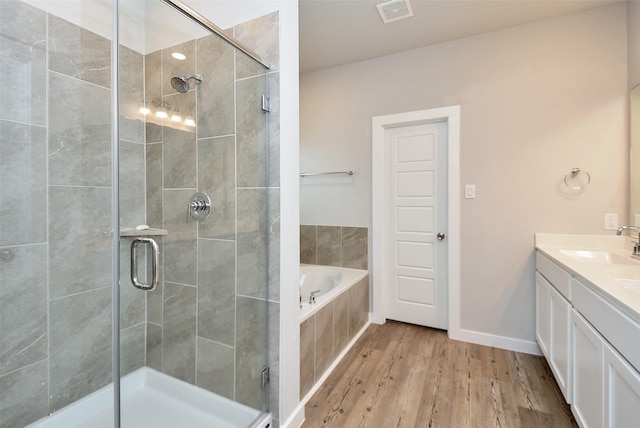 bathroom with vanity, independent shower and bath, and wood-type flooring