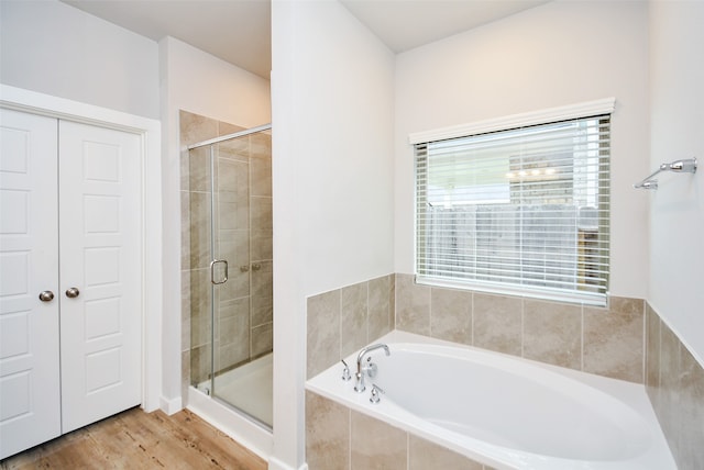 bathroom featuring hardwood / wood-style flooring and independent shower and bath